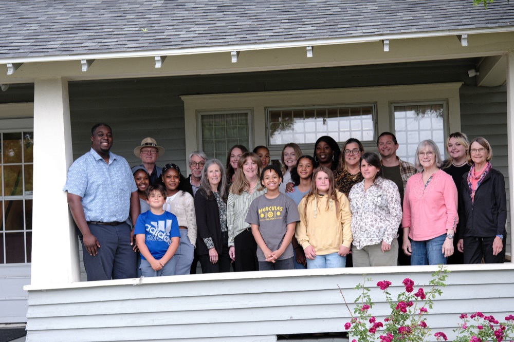Luc with a large group of Spokane neighbors of all ages on a front porch