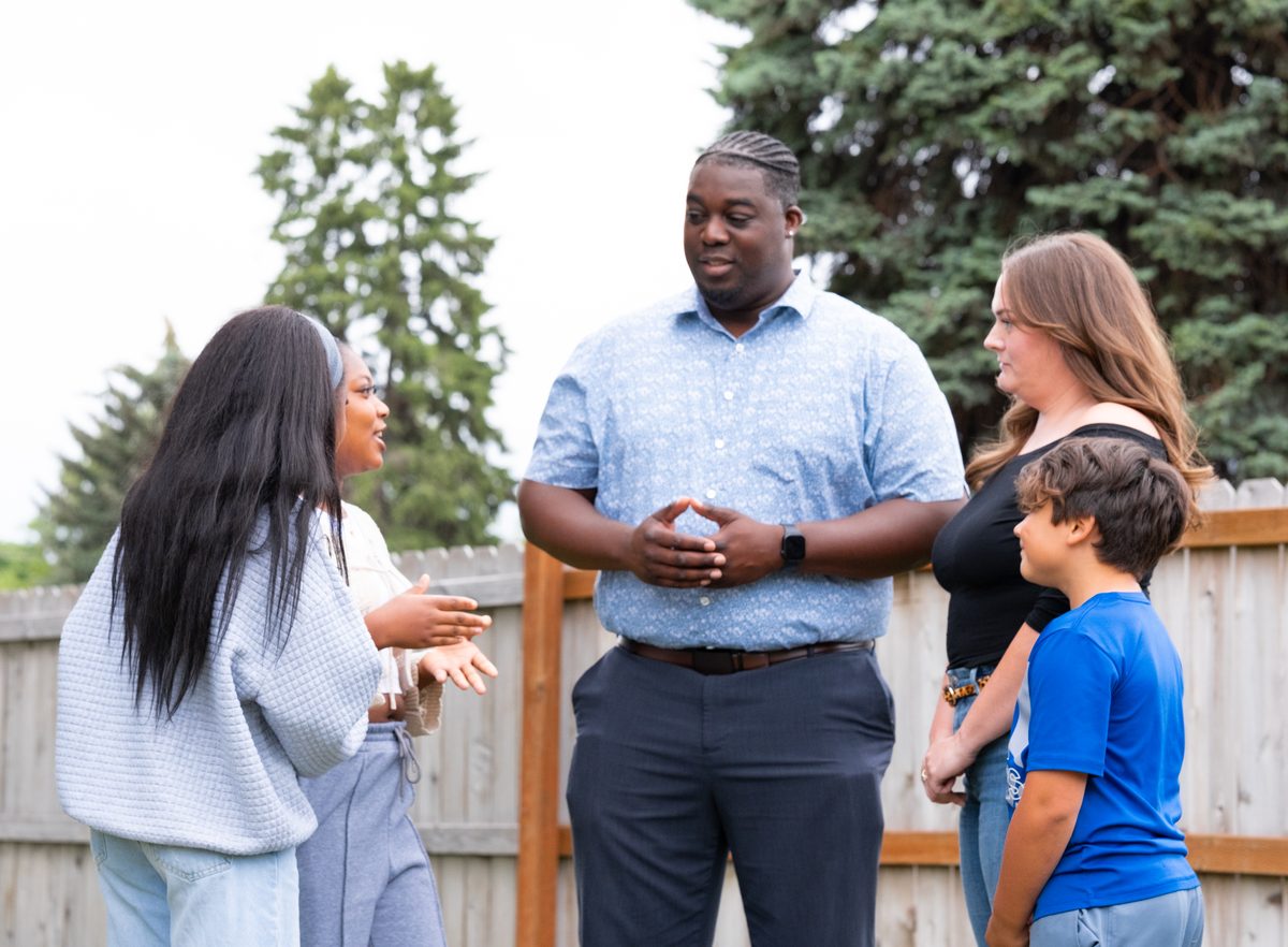 Luc sharing a laugh with a neighbor at her front door