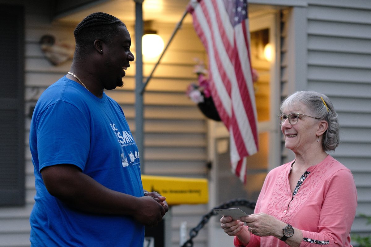 Luc sharing a laugh with a neighbor at her front door