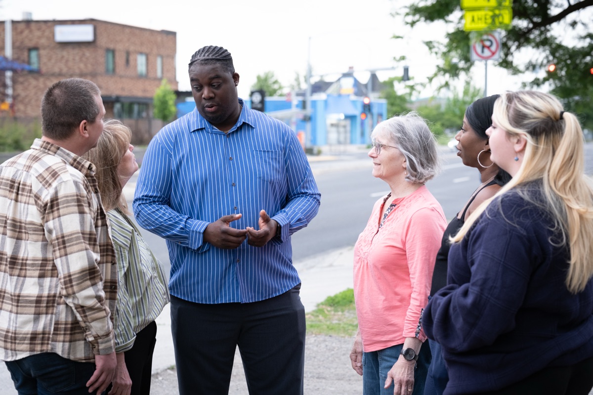 Luc talking with a group of neighbors on a Spokane street corner